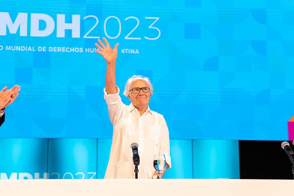 Adolfo Pérez Esquivel, Premio Nobel de la Paz y presidente honorario del Foro, saluda con la mano en alto en el escenario del FMDH2023.