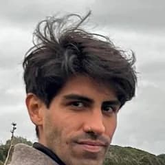 Maximiliano Valdez Aires con un tapado gris y los brazos cruzados, en un mirador sobre la costa.