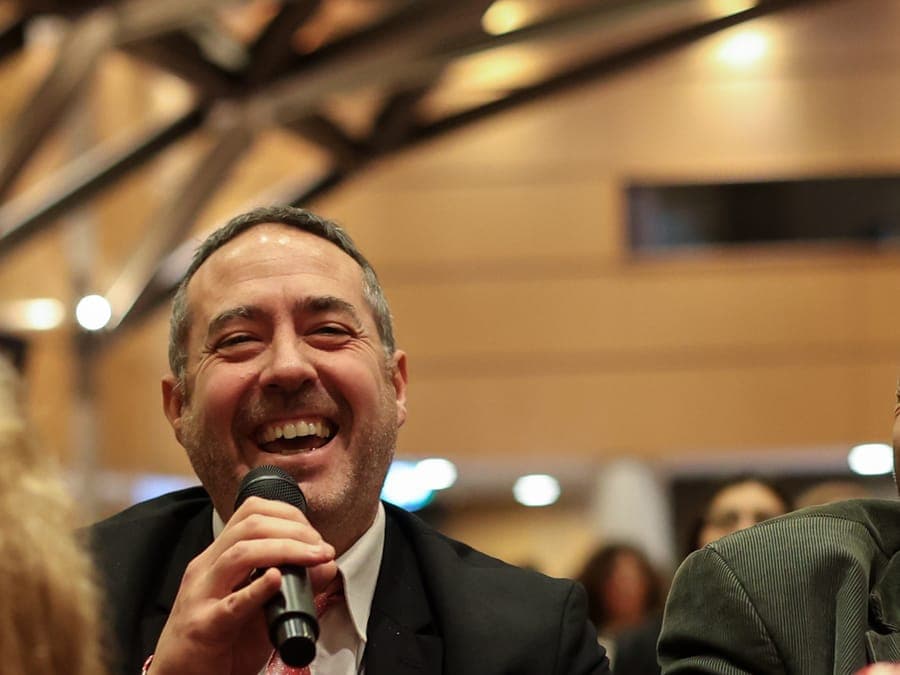 Un asistente hace una pregunta con el micrófono durante un panel.