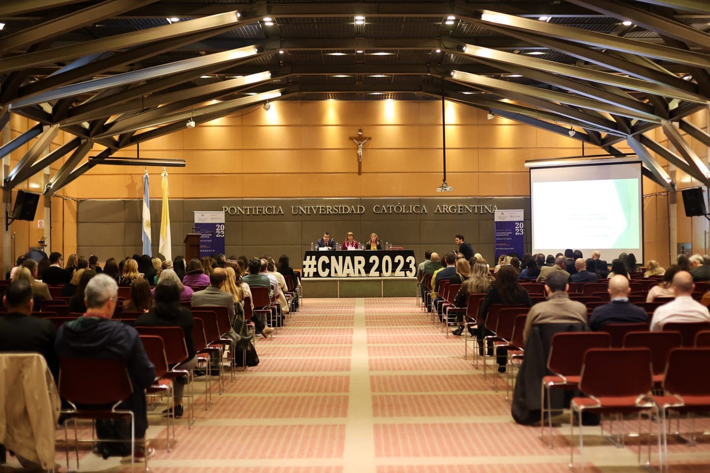 Auditorio de la UCA lleno durante la segunda edición, con el #CNAR2023 en el escenario